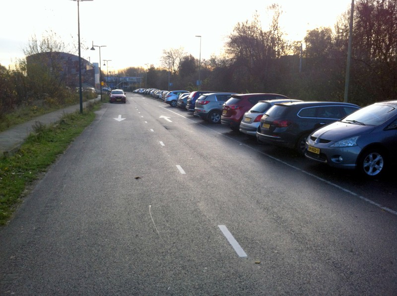 Rijen autos op parkeerplekken tussen Boerderij en Eten Zo