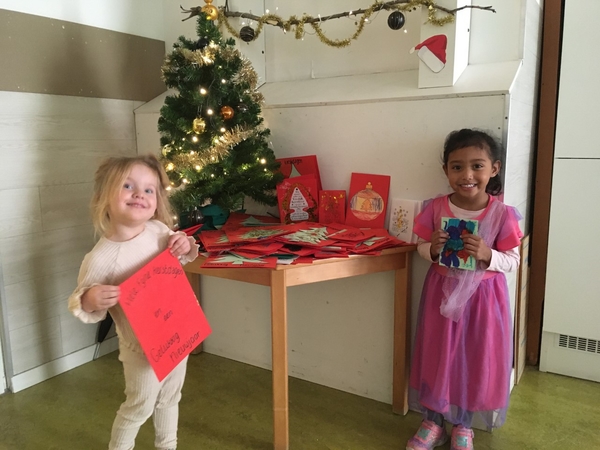 Kinderen laten zelfgemaakte kerstkaarten zien