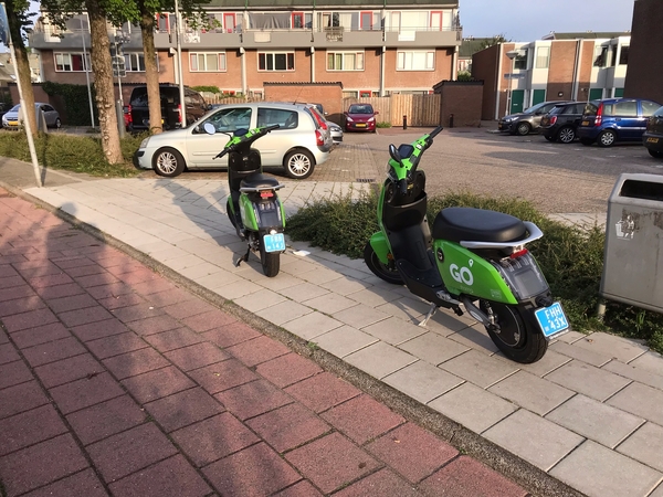 twee deelscooters op trotoir