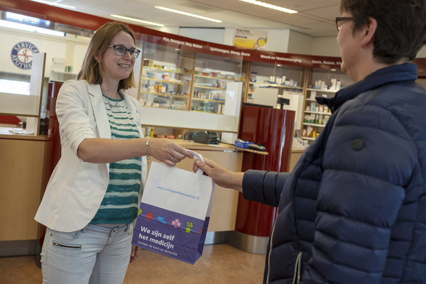 Zoetermeer, 13 juni 2022Appotheker Renée Peeters reikt een zakje aan met "we zijn zelf het medicijn".