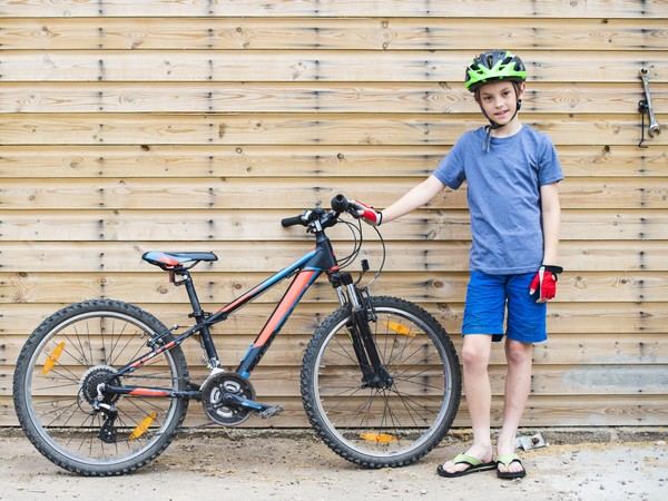 Young boy standing with his bike