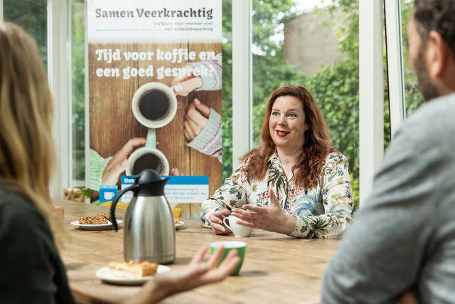 Drie mensen aan een koffietafel voor een poster van Samen Veerkrachtig