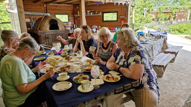 Een groep mensen genietend van een high tea bij de Hof van Seghwaert